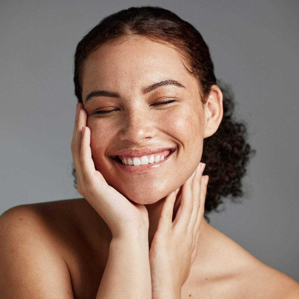 Gesicht, Schönheit und Zufriedenheit einer schwarzen Model-Frau im Studio vor grauem Hintergrund zur Werbung für natürliche Hautpflege. Gesichtsbehandlung, Wellness und Make-up mit einer attraktiven jungen Frau, die mit Kosmetikprodukten zufrieden ist